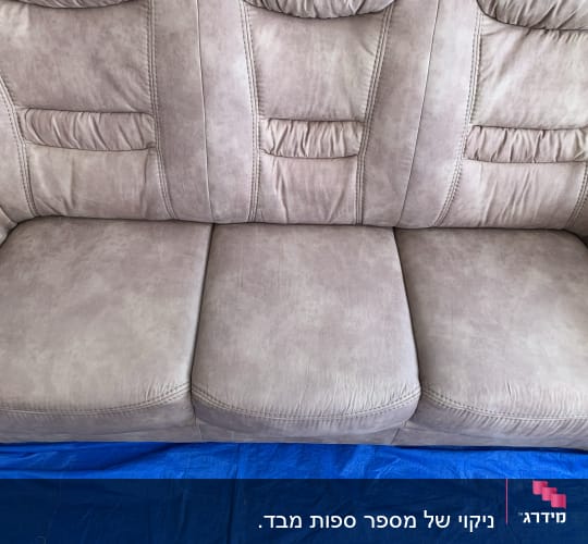 ספה חומה עם כיסוי כחול מתחת